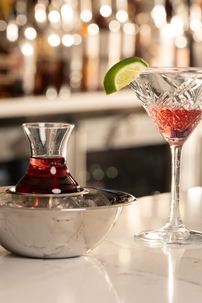 Bartolino's Glass Of Dark Red Alcohol With Lime And Decanter
