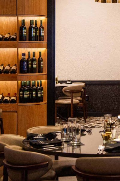 Interior shot of Bartolino's The Hill restaurant, featuring wine and spirits, dining ware and glassware set at tables